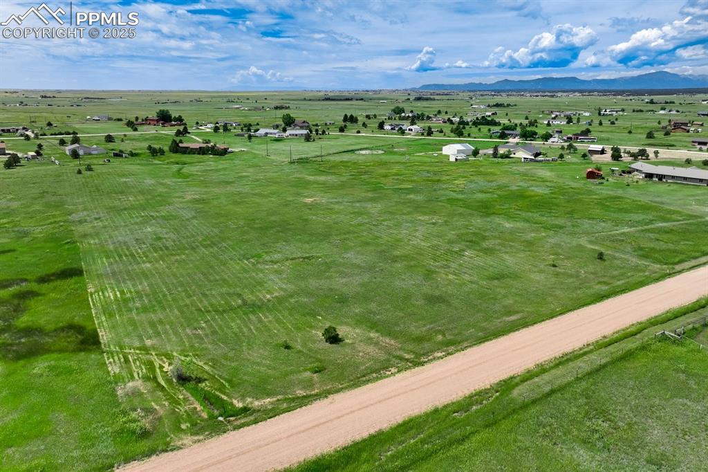 Image 4: Overview of rural landscape featuring a mountainous background and a pastoral area