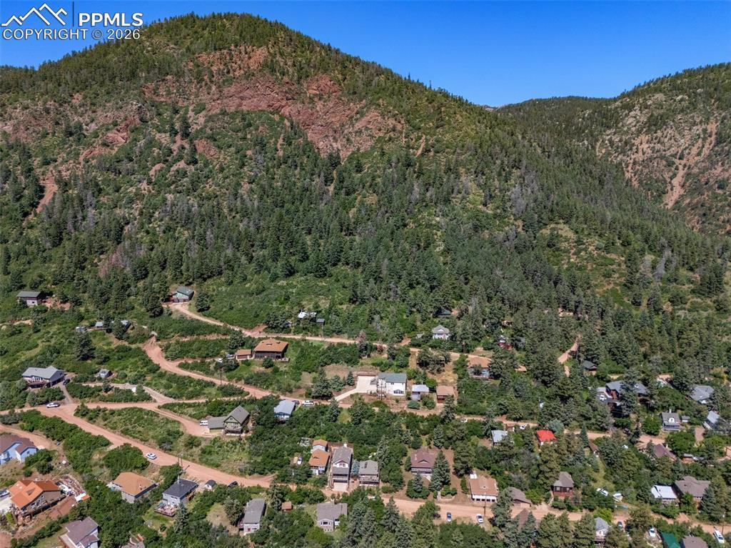 Image 3: Drone / aerial view of a mountain backdrop and a heavily wooded area
