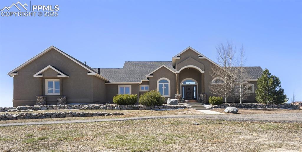 Image 1: View of front of home with stucco siding and roof with shingles