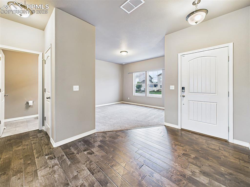 Image 2: Bright and open foyer with LVP flooring looks like rich hardwood flooring and access to a convenient half bath and front-facing flex room.