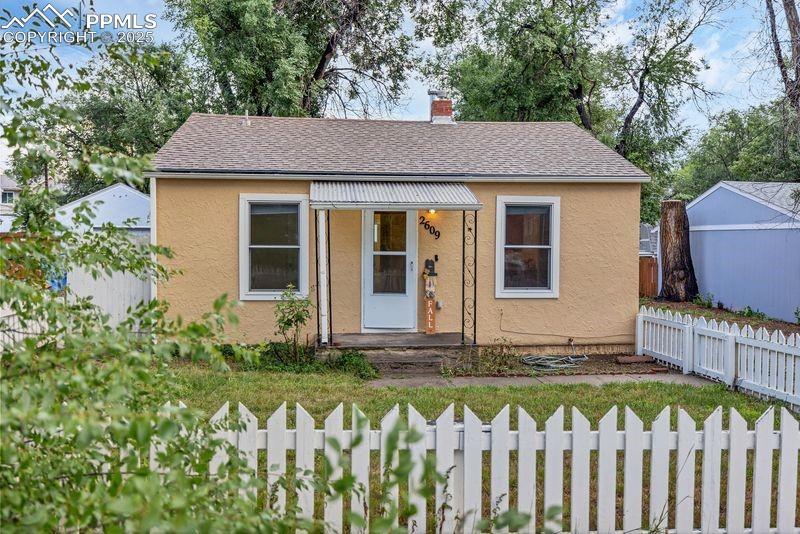 Image 1: Bungalow-style house with a fenced front yard, roof with shingles, a chimney, stucco siding, and a porch