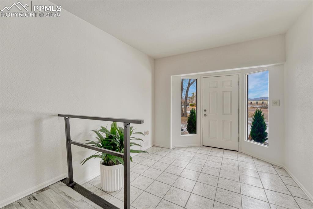 Image 3: One of the 2 front entrances, with a large tile foyer and window panels for more light.