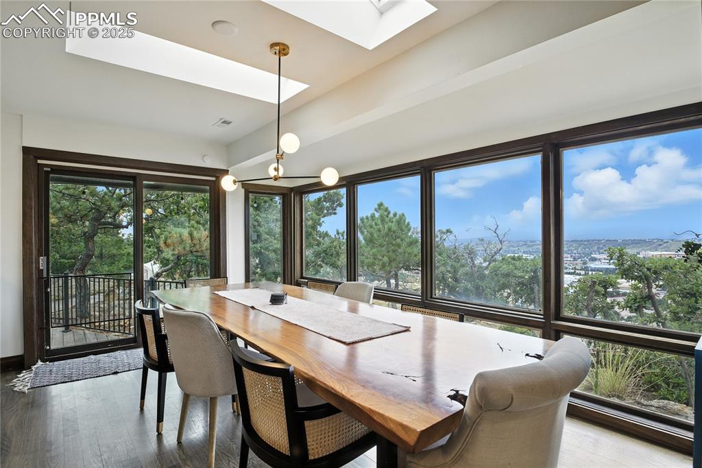 Image 3: Dining area with a skylight and dark wood-style floors