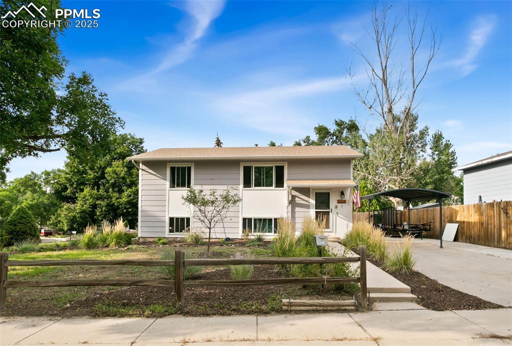 Image 1: Split foyer home featuring concrete driveway and a carport