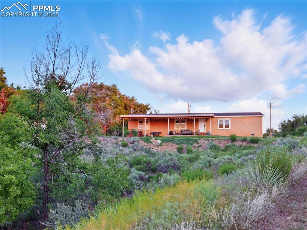 Image 3: Back of home with stucco siding and a patio