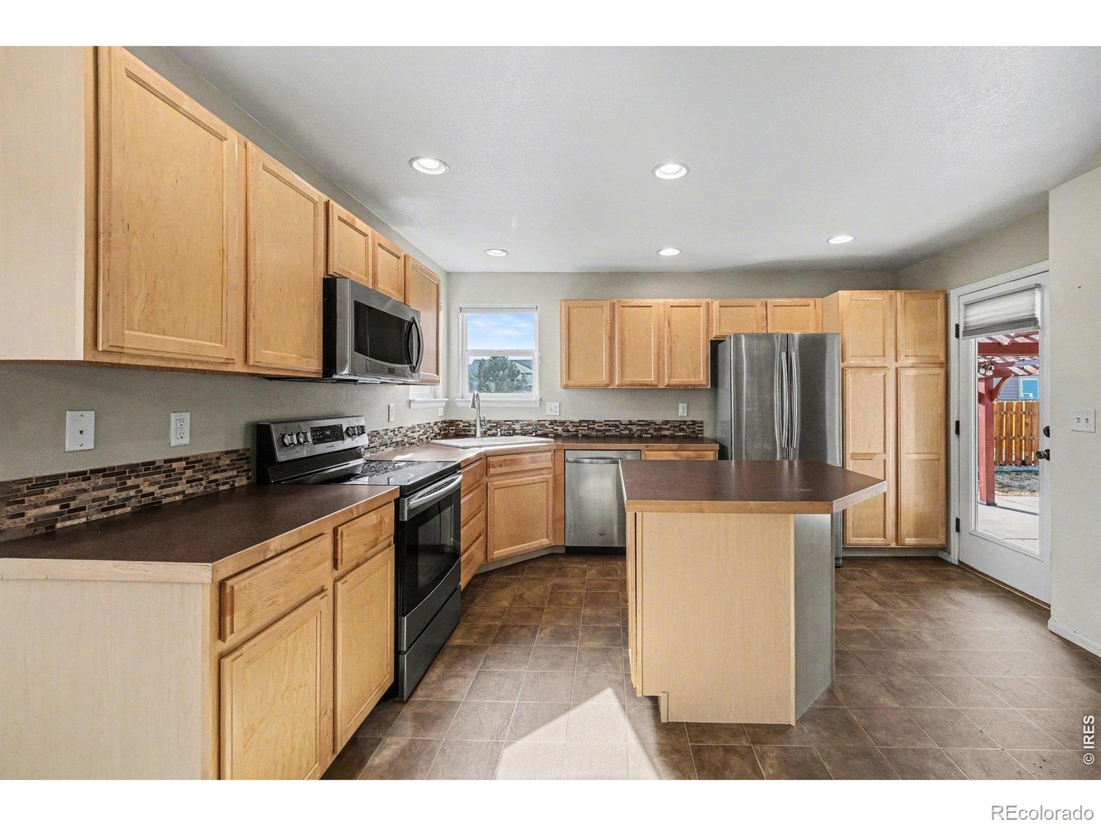 Image 4: Kitchen has a spacious island and beautiful tile backsplash Image 4: Kitchen has a spacious island and beautiful tile backsplash