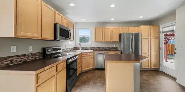 Image 4: Kitchen has a spacious island and beautiful tile backsplash Image 4: Kitchen has a spacious island and beautiful tile backsplash