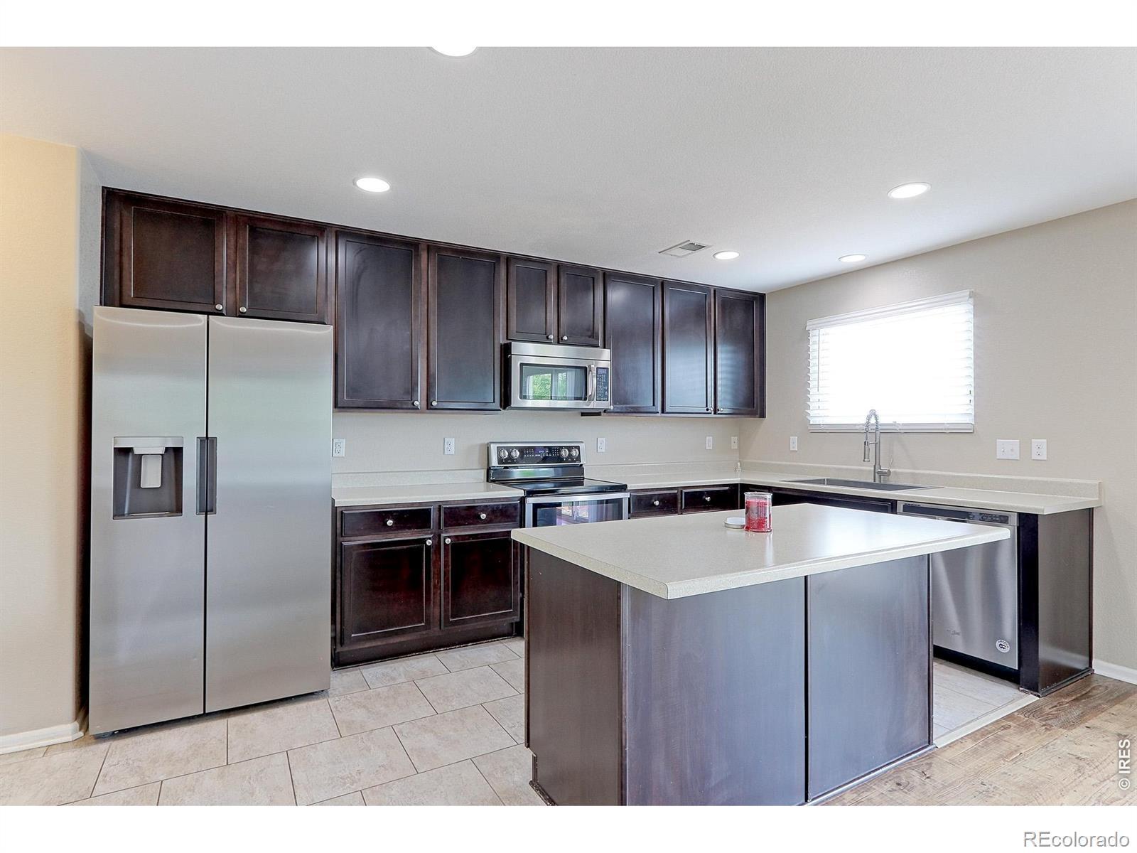 Image 4: The 14x9 kitchen has designer tile floors, oversized Ebony-stained Maple cabinets with brush nickel pulls and solid surface countertops. Image 4: The 14x9 kitchen has designer tile floors, oversized Ebony-stained Maple cabinets with brush nickel pulls and solid surface countertops.