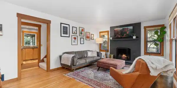Image 3: Living room with wood burning fireplace and hardwood floors. Image 3: Living room with wood burning fireplace and hardwood floors.