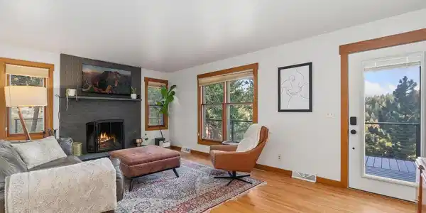 Image 4: Living room with wood burning fireplace and hardwood floors. Image 4: Living room with wood burning fireplace and hardwood floors.