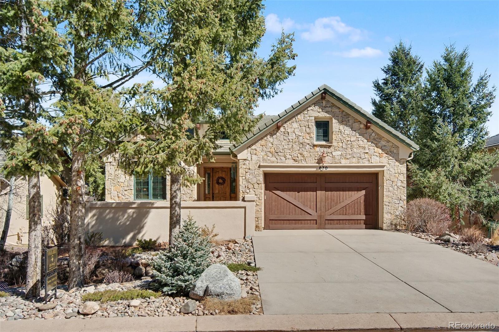 Image 1: Arrive home to timeless architecture and the inviting charm of your private front courtyard. Stucco and stone exterior with a concrete tile roof.