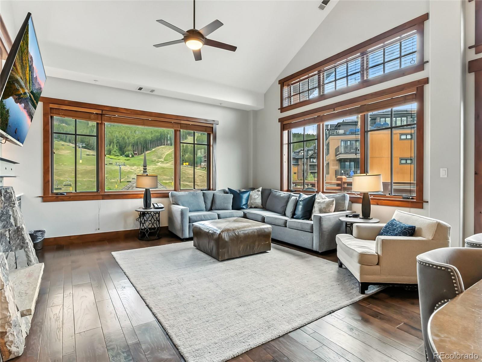 Image 3: Living area featuring plenty of natural light, a ceiling fan, high vaulted ceiling, panoramic views, and dark wood-style flooring