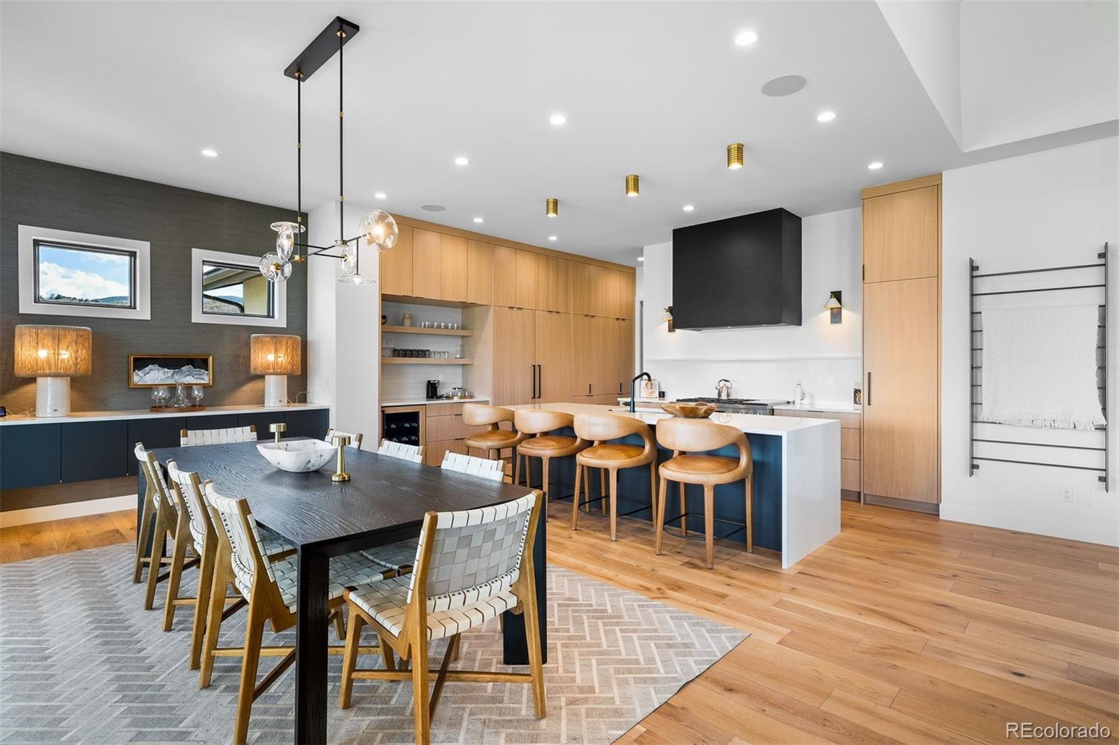 Image 3: Open-concept dining anchored by custom cabinetry and a quartz waterfall island. Image 3: Open-concept dining anchored by custom cabinetry and a quartz waterfall island.