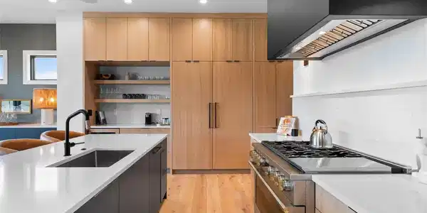 Image 4: Monogram range framed by white oak cabinetry and clean-lined finishes.