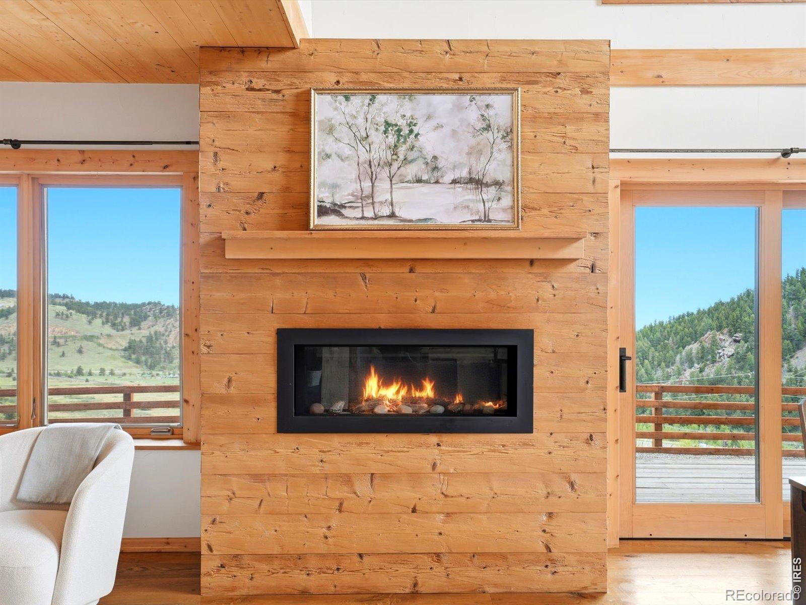 Image 3: A modern gas fireplace anchors the living space with warmth and visual appeal. The custom wood surround complements the homes natural aesthetic and creates a cozy focal point. Image 3: A modern gas fireplace anchors the living space with warmth and visual appeal. The custom wood surround complements the homes natural aesthetic and creates a cozy focal point.