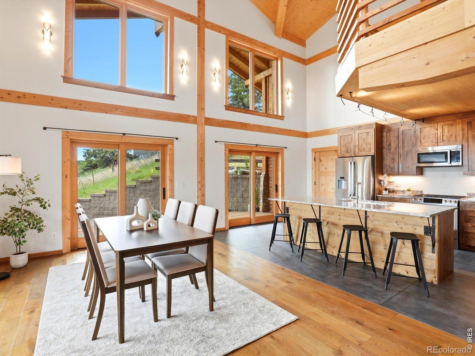 Image 4: The dining area is perfectly positioned beneath dramatic two-story ceilings and surrounded by large windows that capture natural light and scenic views. Sliding doors provide easy access to outdoor living spaces. Image 4: The dining area is perfectly positioned beneath dramatic two-story ceilings and surrounded by large windows that capture natural light and scenic views. Sliding doors provide easy access to outdoor living spaces.