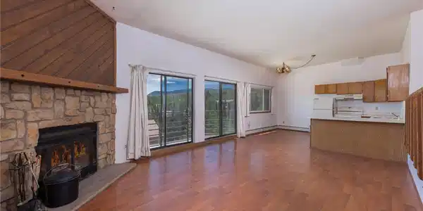 Image 2: Great room with wood fireplace, laminate wood flooring, a stone fireplace Image 2: Great room with wood fireplace, laminate wood flooring, a stone fireplace