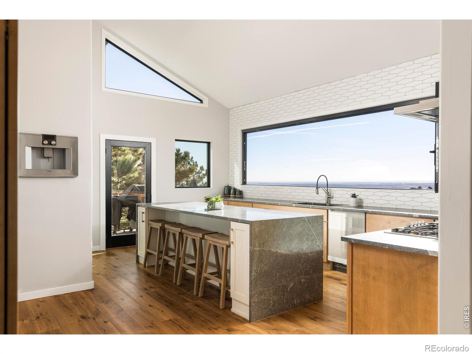 Image 4: The kitchen centers on a dramatic waterfall island complemented by a full suite of Gaggenau appliances. Image 4: The kitchen centers on a dramatic waterfall island complemented by a full suite of Gaggenau appliances.