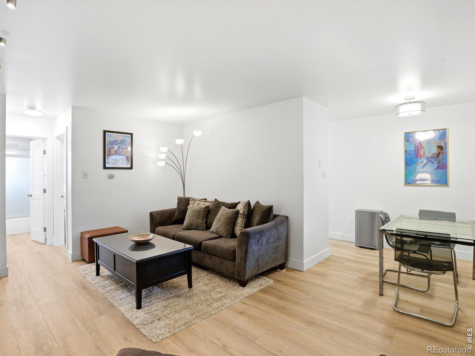 Image 4: Bright, open-concept living space featuring updated flooring, fresh finishes, and a comfortable layout that flows seamlessly into the dining area.