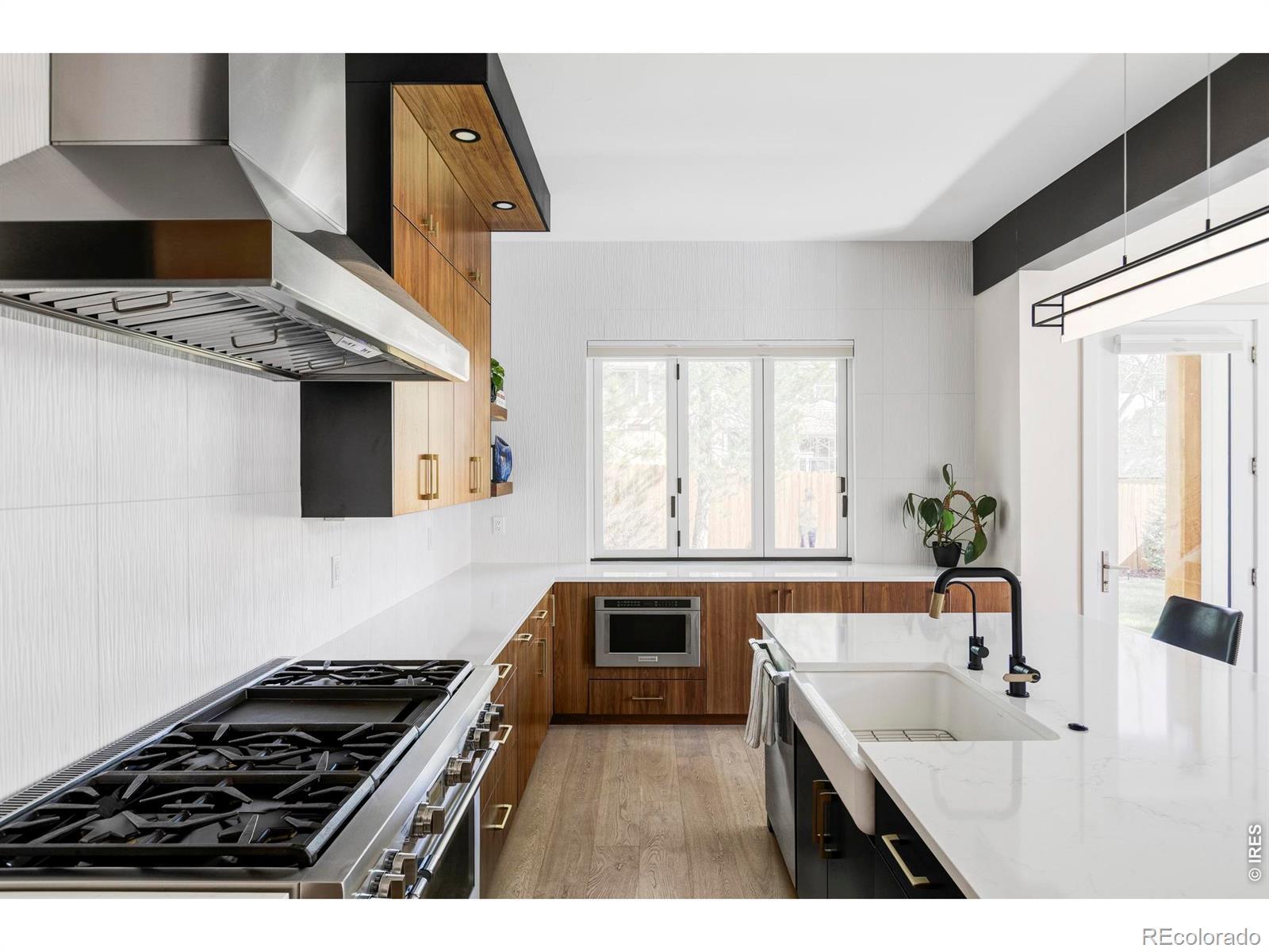 Image 3: The kitchen anchors the space, featuring black walnut cabinetry, a large island for seating and prep, and a nearby walk-in pantry that keeps daily storage tucked out of sight. Image 3: The kitchen anchors the space, featuring black walnut cabinetry, a large island for seating and prep, and a nearby walk-in pantry that keeps daily storage tucked out of sight.