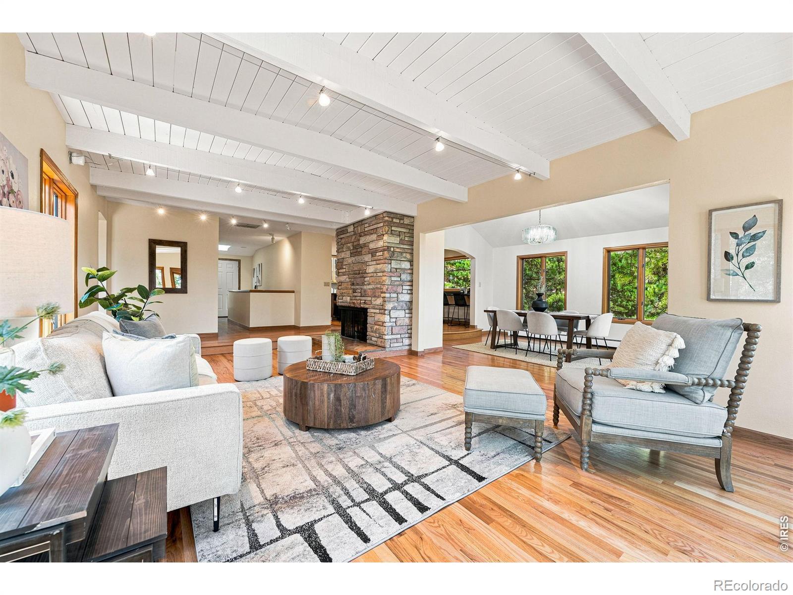 Image 3: The entry level is an open floor plan, with natural light flowing through the space. A wood-burning fireplace connects the living, dining, and kitchen.