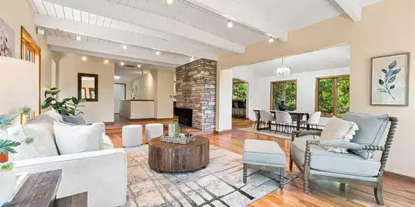 Image 3: The entry level is an open floor plan, with natural light flowing through the space. A wood-burning fireplace connects the living, dining, and kitchen.