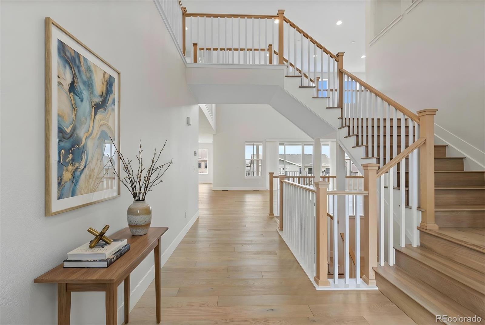 Image 3: A grand, light-filled foyer showcases soaring ceilings, warm wood floors, and an elegant staircase that sets a refined tone for the home. *This photo has been virtually staged. Image 3: A grand, light-filled foyer showcases soaring ceilings, warm wood floors, and an elegant staircase that sets a refined tone for the home. *This photo has been virtually staged.
