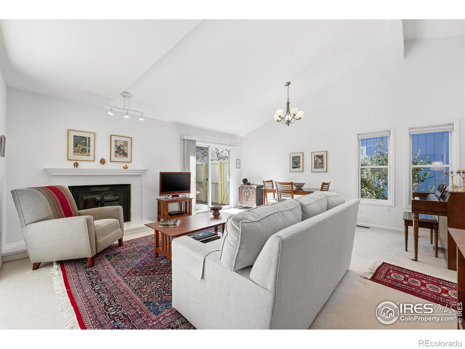 Image 2: Vaulted ceilings, abundant natural light, and a wood-burning fireplace create a welcoming main living space Image 2: Vaulted ceilings, abundant natural light, and a wood-burning fireplace create a welcoming main living space