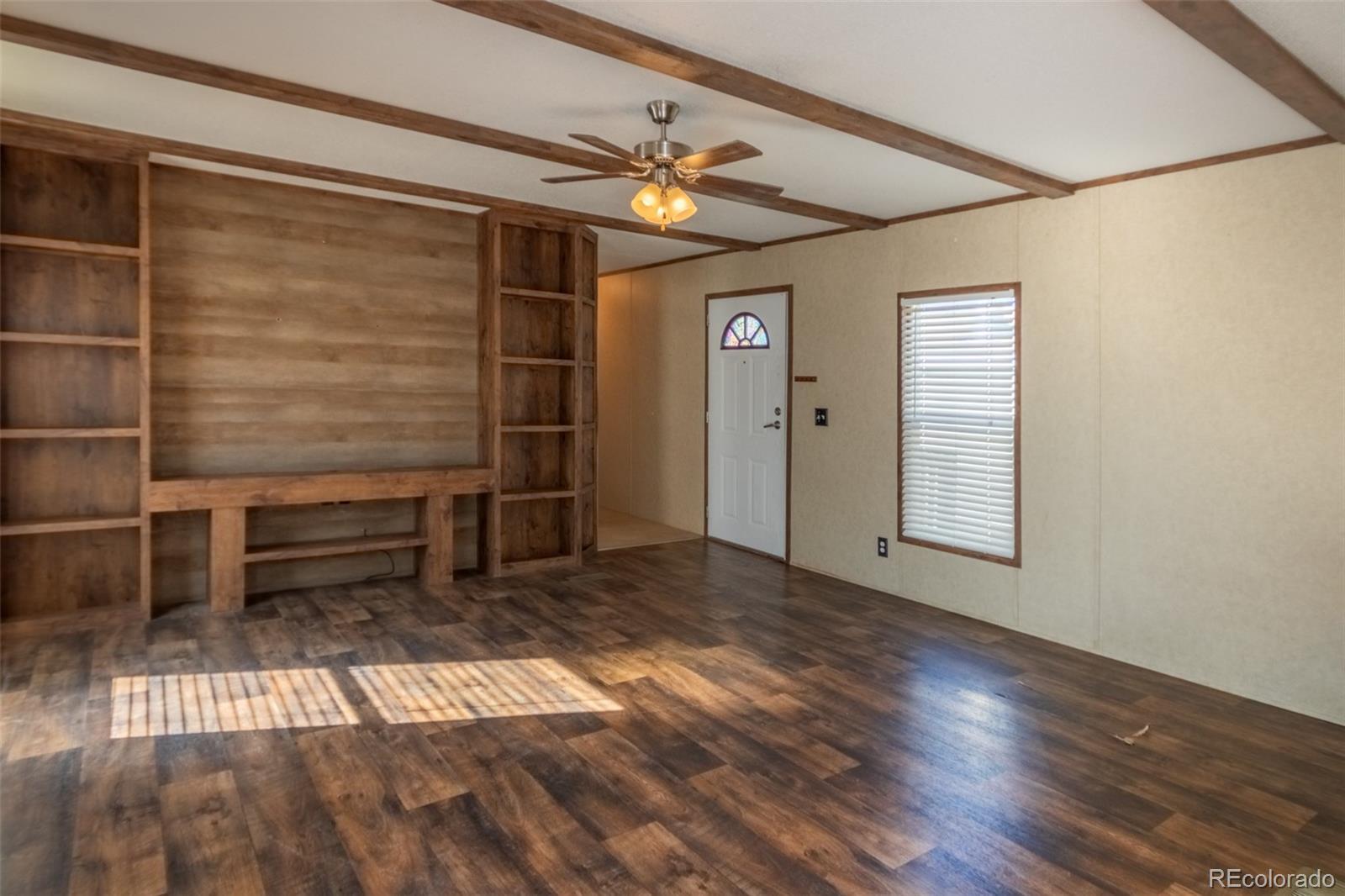 Image 2: Living room with built in shelving.