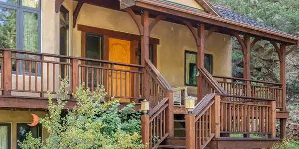 Image 2: A welcoming front porch and wraparound deck create an inviting arrival surrounded by towering pines. Image 2: A welcoming front porch and wraparound deck create an inviting arrival surrounded by towering pines.