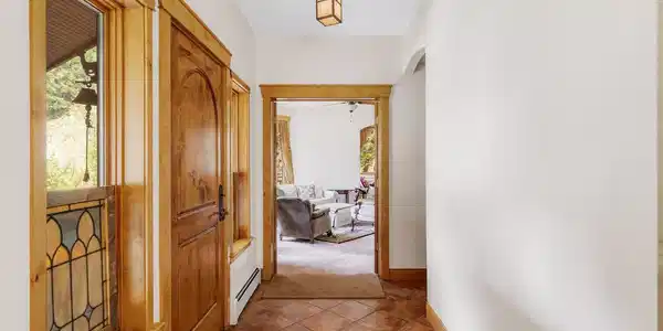 Image 3: Bright entry hall with handcrafted wood details and a glimpse into the homes warm, light filled interior. Image 3: Bright entry hall with handcrafted wood details and a glimpse into the homes warm, light filled interior.