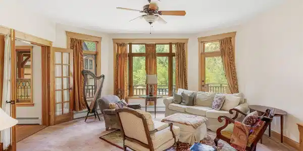 Image 4: The main living room is filled with natural light, generous windows, and peaceful views of the surrounding forest. Image 4: The main living room is filled with natural light, generous windows, and peaceful views of the surrounding forest.