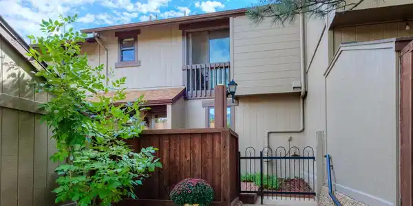 Image 2: Front of the townhome with gardens and a large private deck. Image 2: Front of the townhome with gardens and a large private deck.
