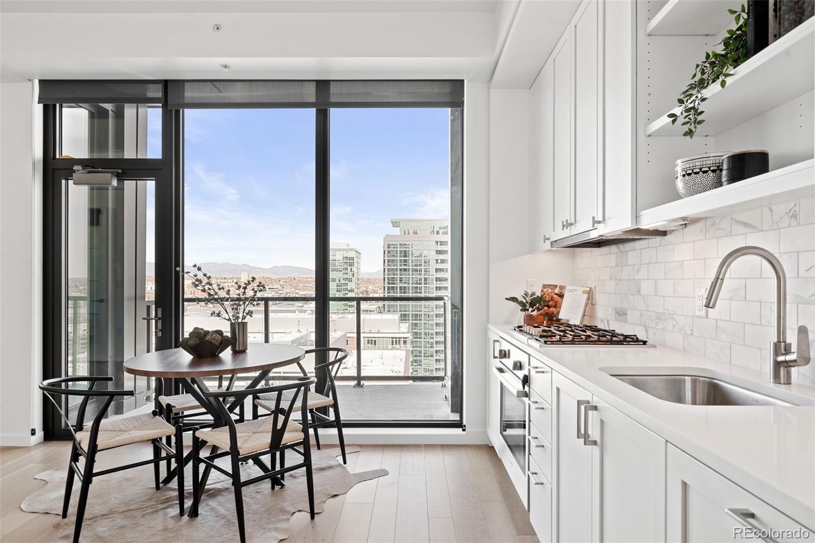 Image 3: Kitchen with floor to ceiling windows, deck, and mountain view