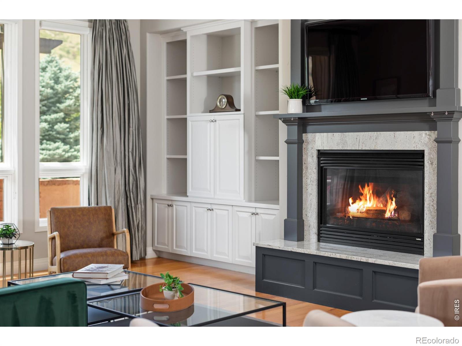 Image 4: The main living room features wood floors, high ceilings, western Foothill views through large picture windows, and is anchored by a fireplace and custom built-ins. Image 4: The main living room features wood floors, high ceilings, western Foothill views through large picture windows, and is anchored by a fireplace and custom built-ins.