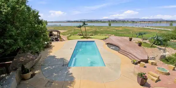 Image 4: Elevated view showcases the pool, outdoor entertaining areas and spectacular reservoir and Front Range backdrop. Image 4: Elevated view showcases the pool, outdoor entertaining areas and spectacular reservoir and Front Range backdrop.