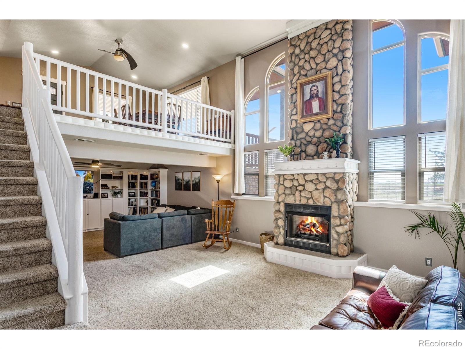Image 1: The lower level is no less impressive with the large west facing windows and stone gas fireplace.