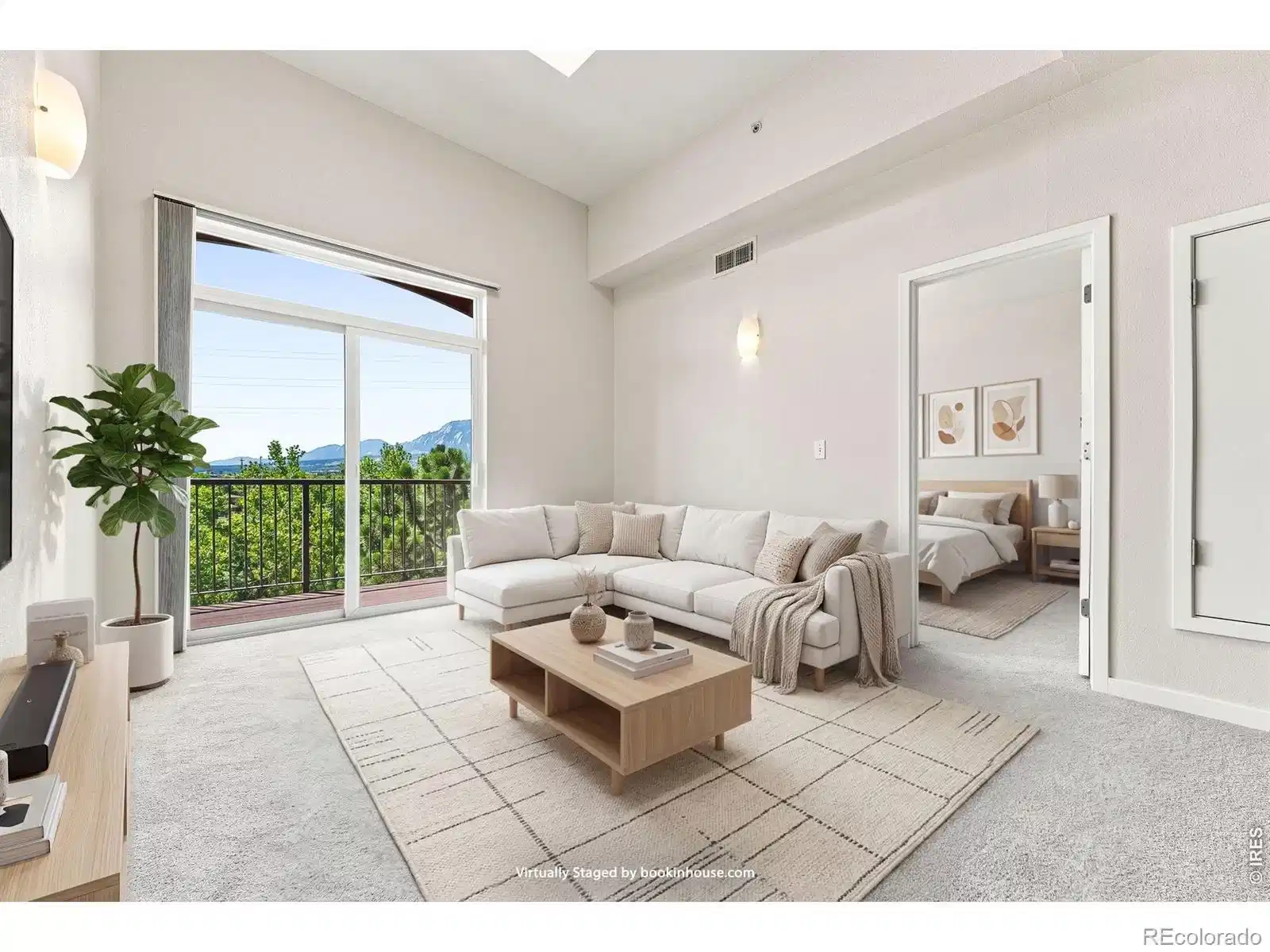 Image 1: Vaulted south facing living room with vaulted ceilings, skylight and sliding door leading to balcony.  This photo is virtually staged