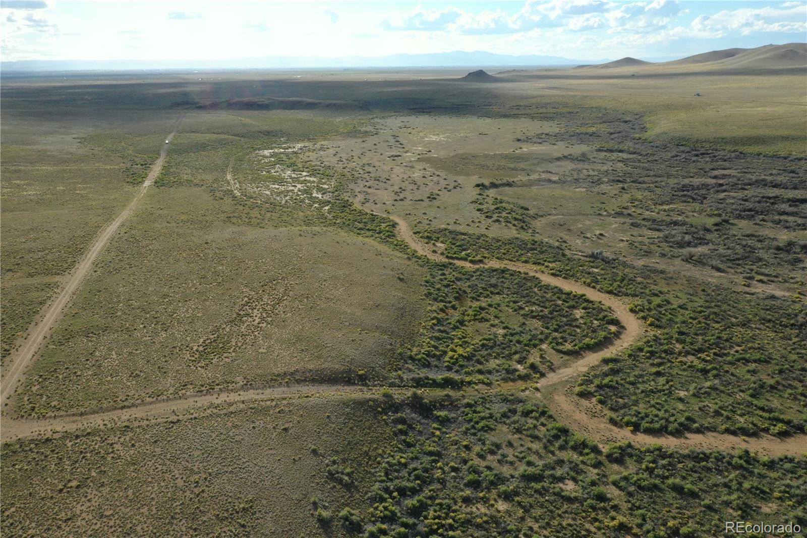 Image 1: Aerial view looking west, mostly level with rolling hills and natural vegetation.