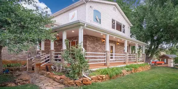 Image 2: The back of the home at twilight, opening to the covered deck and lawn.