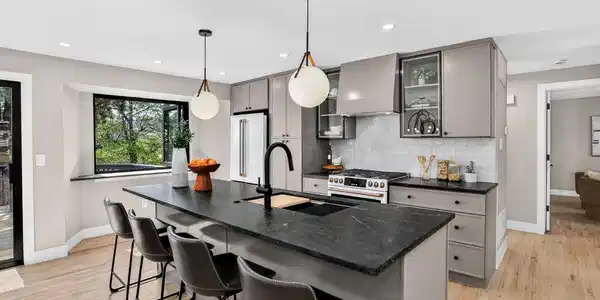 Image 3: An undermount workstation sink, hand-set tile backsplash, and matte black fixtures finish the room. Image 3: An undermount workstation sink, hand-set tile backsplash, and matte black fixtures finish the room.