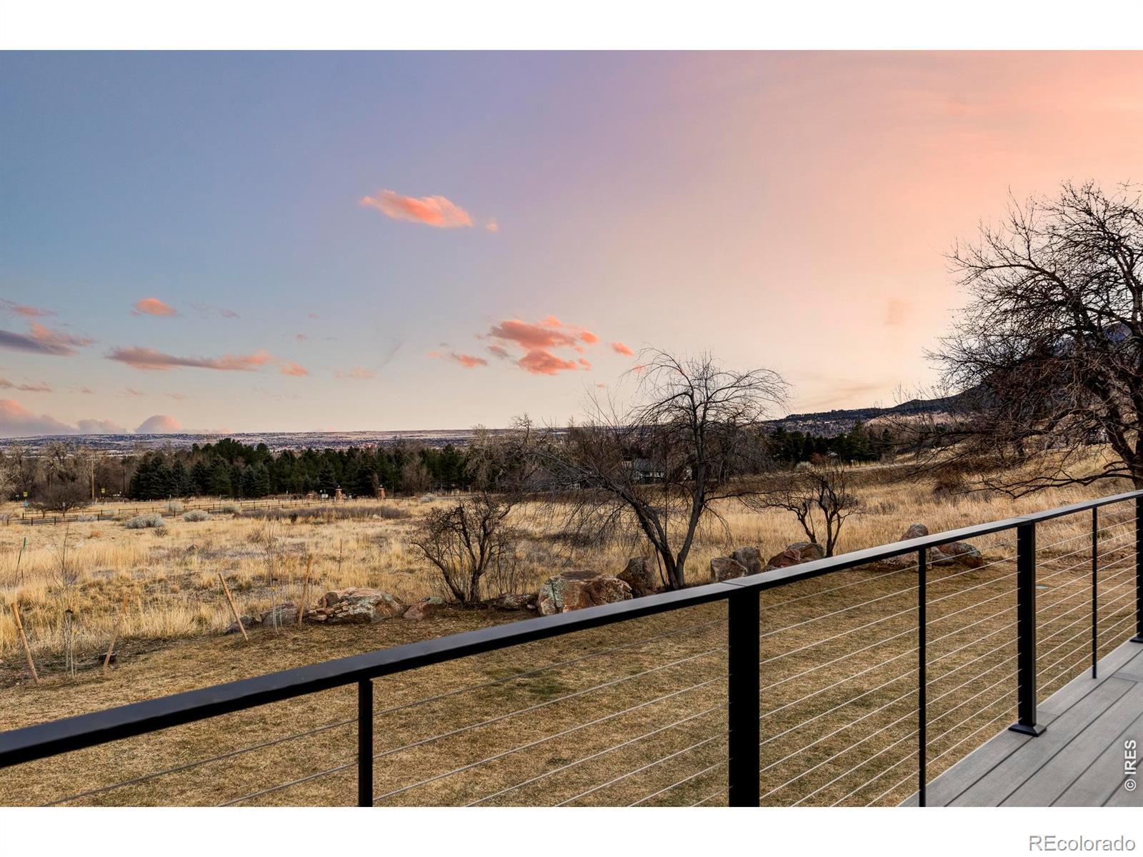Image 4: The brand-new back deck is large, half-covered, and directly accessible from the family room. It overlooks a sweeping backyard that stretches to the edge of Open Space, where natural boulders and south-facing rock outcroppings mark the property line.