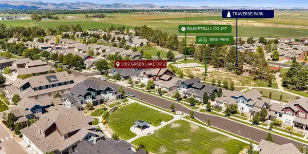 Image 2: Wide aerial view illustrating the propertys close proximity to local amenities, open green belts, and distant mountain backdrops. Image 2: Wide aerial view illustrating the propertys close proximity to local amenities, open green belts, and distant mountain backdrops.
