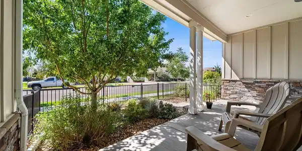 Image 3: Private covered front patio offering a comfortable shaded retreat surrounded by lush landscaping and a fenced yard. Image 3: Private covered front patio offering a comfortable shaded retreat surrounded by lush landscaping and a fenced yard.