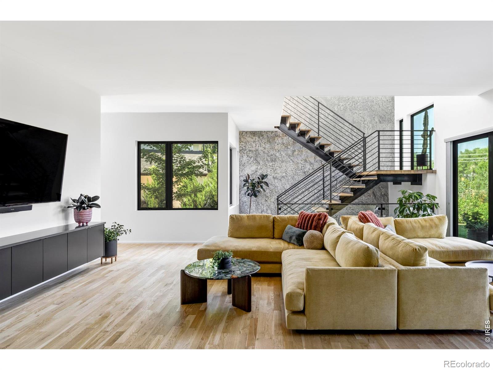 Image 3: The living room welcomes you with soaring ceilings, expansive windows, and a floating steel staircase that creates an architectural focal point while connecting the homes open living spaces. Image 3: The living room welcomes you with soaring ceilings, expansive windows, and a floating steel staircase that creates an architectural focal point while connecting the homes open living spaces.