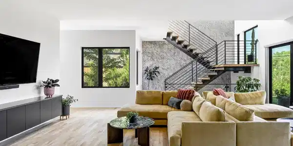 Image 3: The living room welcomes you with soaring ceilings, expansive windows, and a floating steel staircase that creates an architectural focal point while connecting the homes open living spaces. Image 3: The living room welcomes you with soaring ceilings, expansive windows, and a floating steel staircase that creates an architectural focal point while connecting the homes open living spaces.