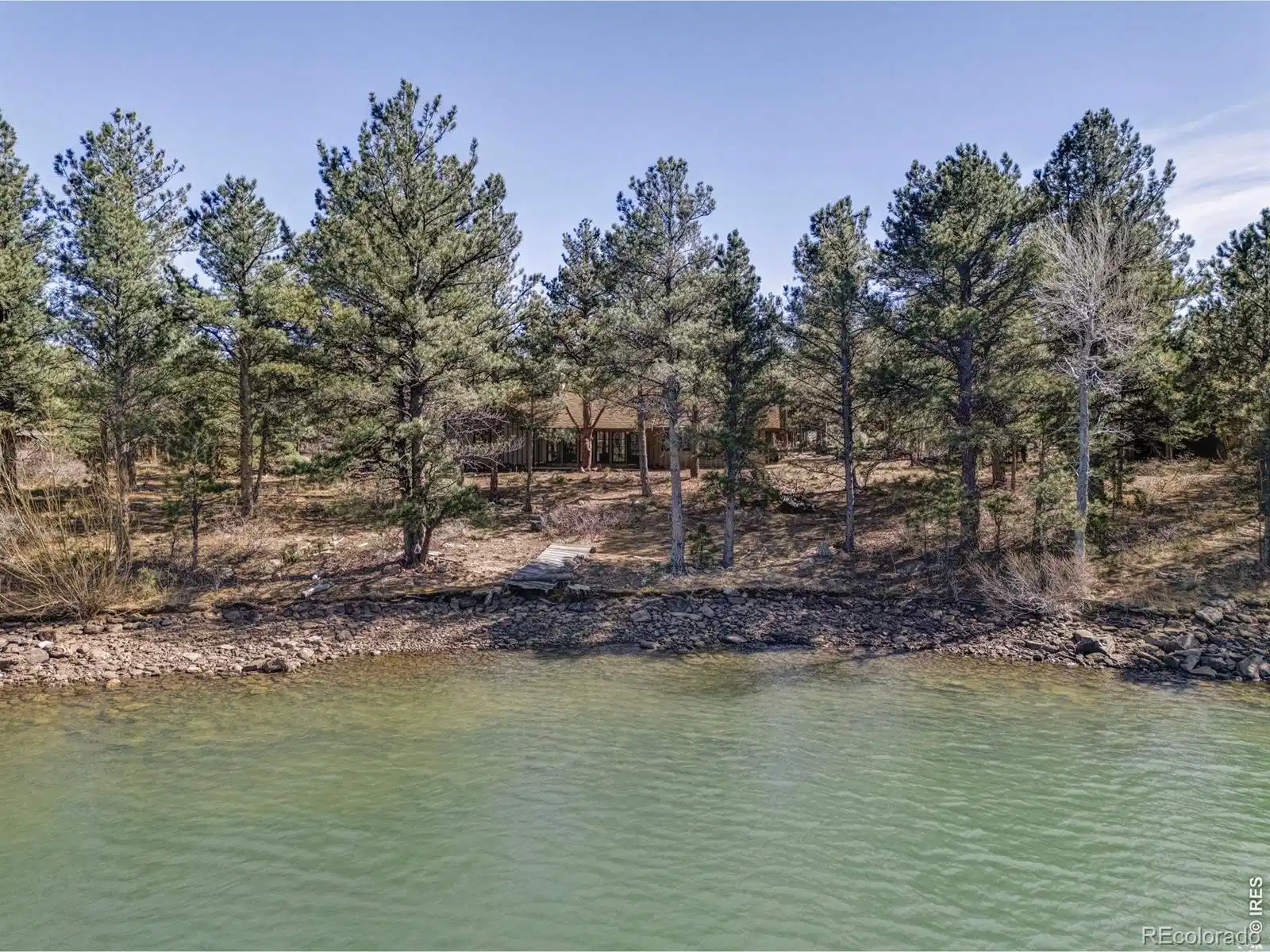 Image 1: Evenings unfold outdoors, surrounded by trees and the stillness of the lake. With direct water access, privacy, and a setting this close to Boulder, opportunities like this are few and far between.