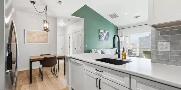 Image 3: The completely remodeled kitchen has had the bar height counter removed to increase working space and truly open it to the dining area and living room.