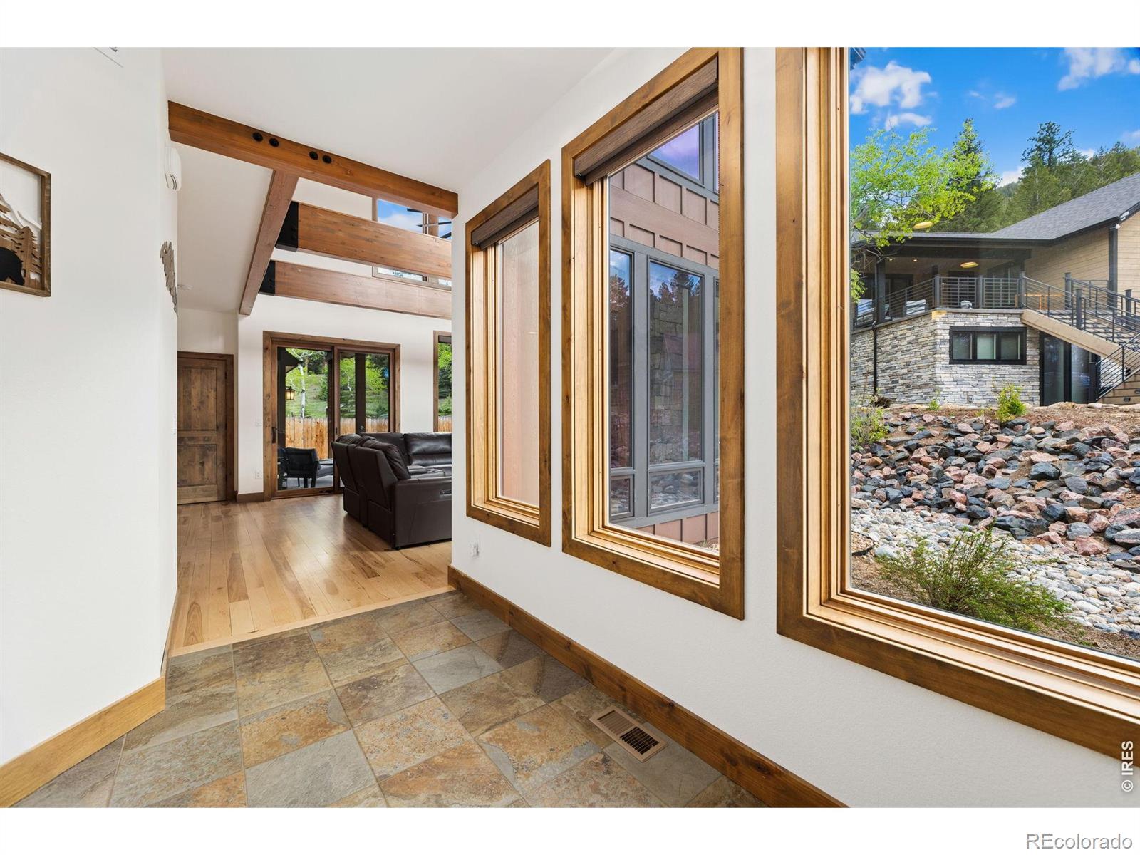 Image 3: The foyer greets you with tile floors and a peek at the beams of the great room Image 3: The foyer greets you with tile floors and a peek at the beams of the great room