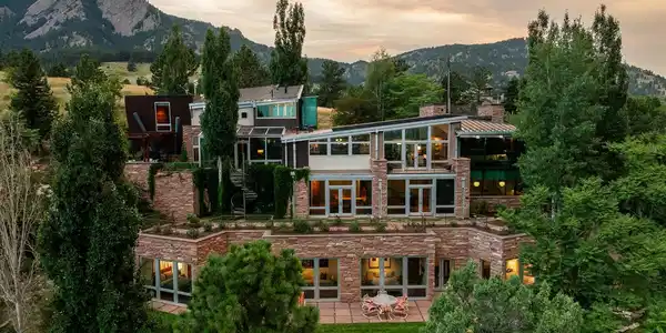Image 2: The main house at dusk, terraced into the hillside below the Flatirons, with the historic Chautauqua Auditorium just beyond in the meadow. The setting cant be reproduced. Image 2: The main house at dusk, terraced into the hillside below the Flatirons, with the historic Chautauqua Auditorium just beyond in the meadow. The setting cant be reproduced.